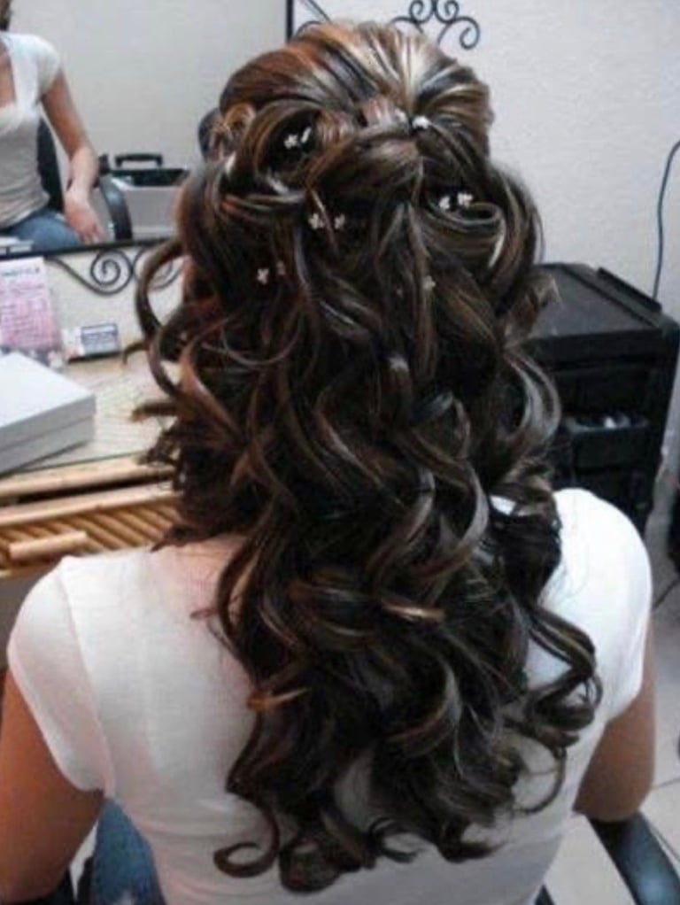 Woman with long dark brown wavy hair with highlights, styled with decorative clips