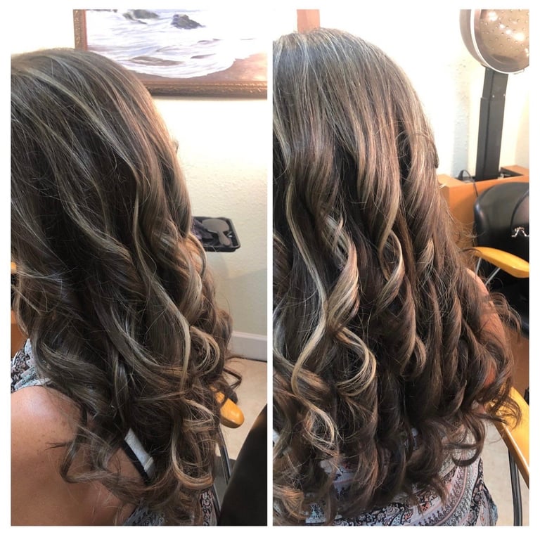Back view of long brunette hair with caramel highlights and loose waves styled in a salon